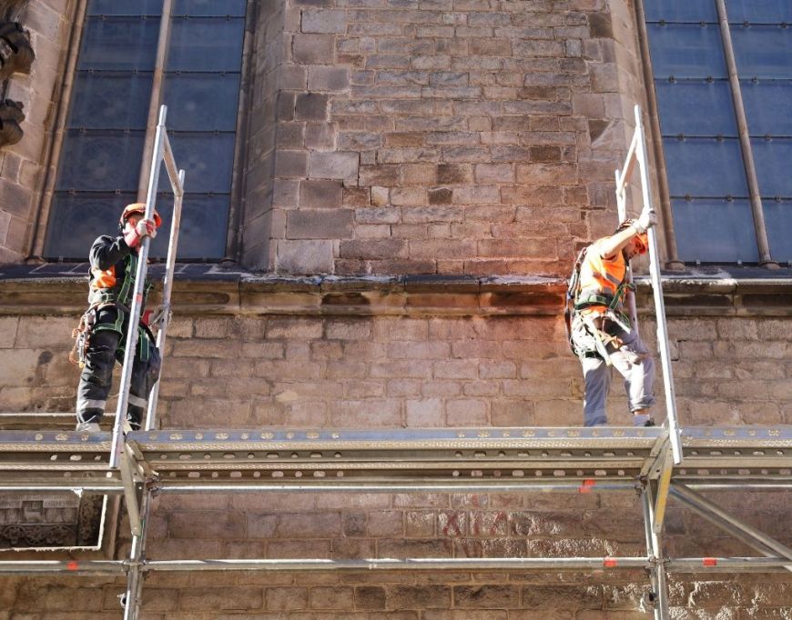 Dos operarios levantando el andamio en Santa Maria del Mar