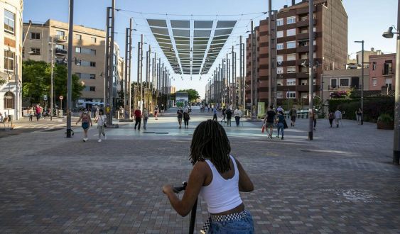 Una jove amb monopatí a la plaça de Sants © Edu Bayer