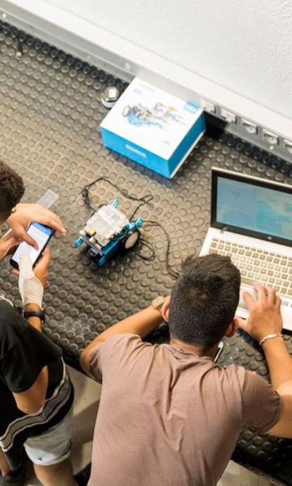 Jóvenes trabajando en un robot por Carlota Serarols