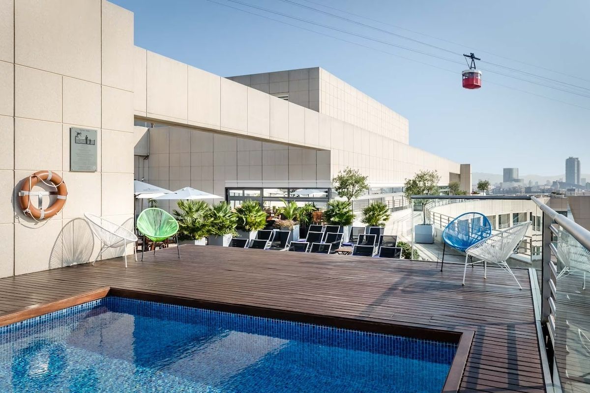 Una de las cabinas del Aeri del Port pasa junto al hotel. El área de la piscina da al paramento sur del muelle de Barcelona (Eurostars)