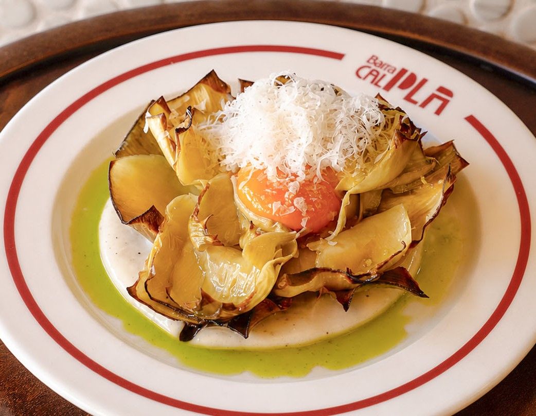 Corazón de alcachofa confitada con crema de queso y yema.