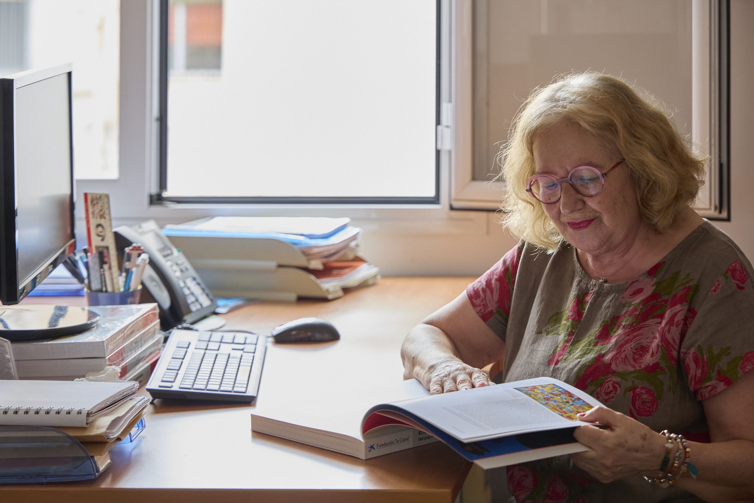 Persona gran en un escriptori amb un llibre. © Fundació "la Caix Persona gran en un escriptori amb un llibre. © Fundació "la Caix