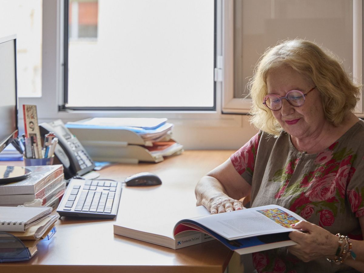 Persona gran en un escriptori amb un llibre. © Fundació "la Caix Persona gran en un escriptori amb un llibre. © Fundació "la Caix