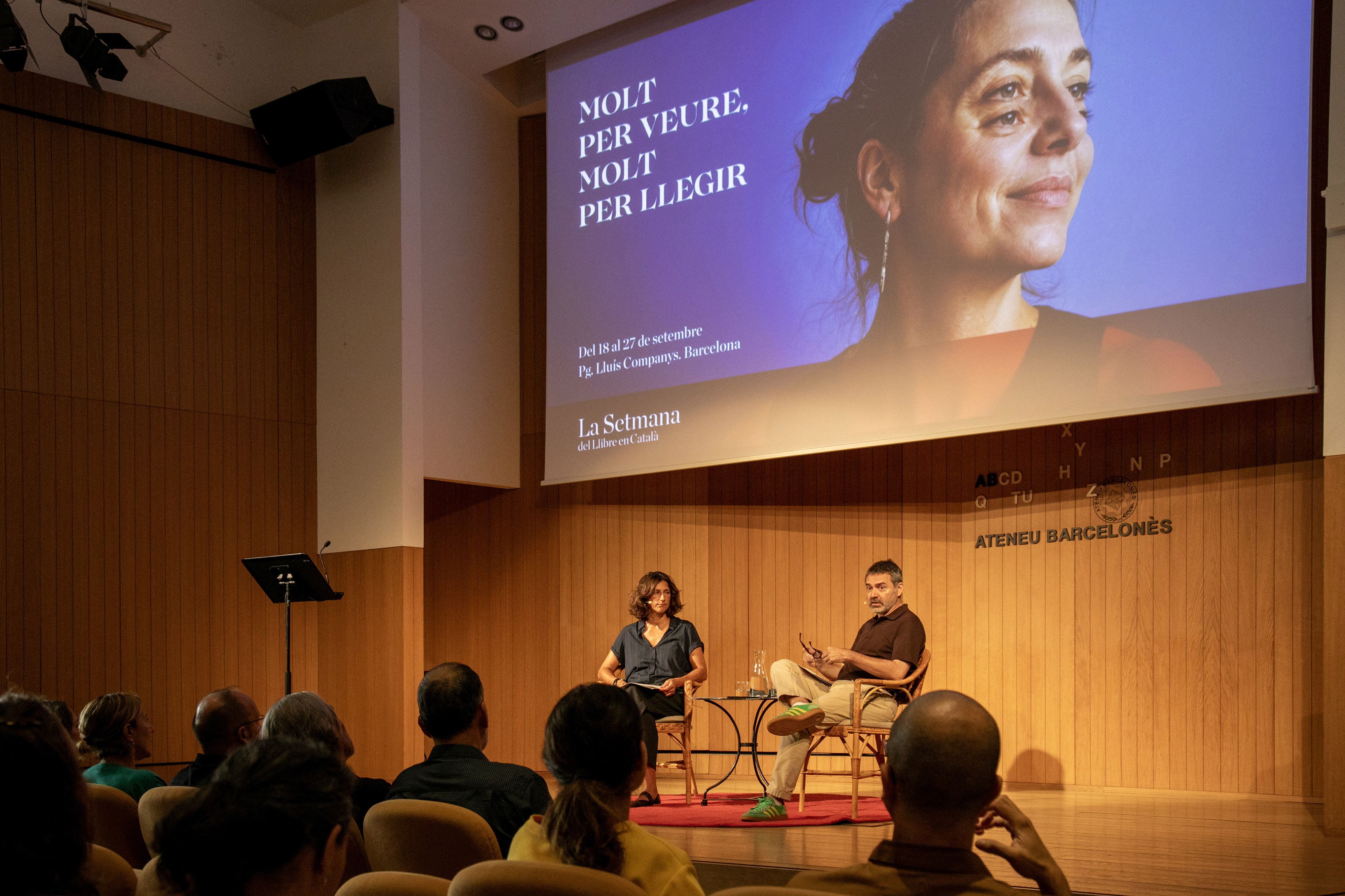 Cristina Domènech, directora de la Setmana, i Oriol Magrinyà, president d'Editors.cat, durant la presentació del programa, amb el cartell de fons. Cristina Domènech, directora de la Setmana, i Oriol Magrinyà, president d'Editors.cat, durant la presentació del programa, amb el cartell de fons.