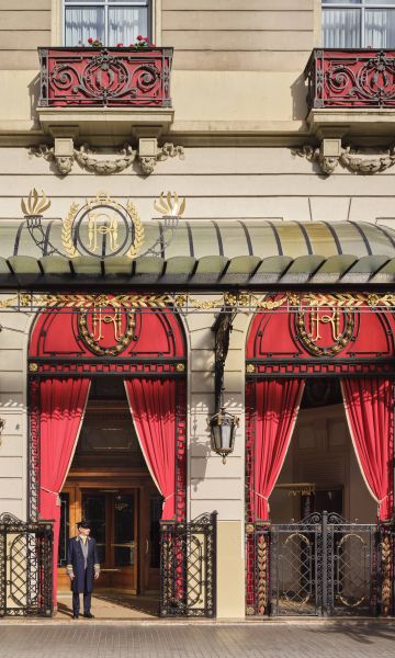 The main entrance to the Palace Hotel in spring 2026. Red dominates the chamfered corner at Gran Via and Roger de Llúria. © Royal Blue Bird