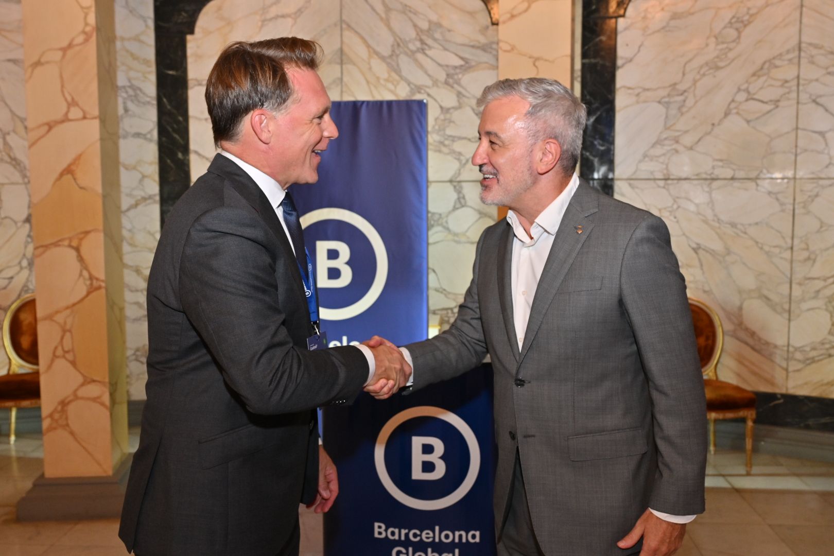 El presidente de Barcelona Global, Josep Lluís Sant Feliu, saluda al alcalde de Barcelona, Jaume Collboni, a su llegada al Palau de Pedralbes.