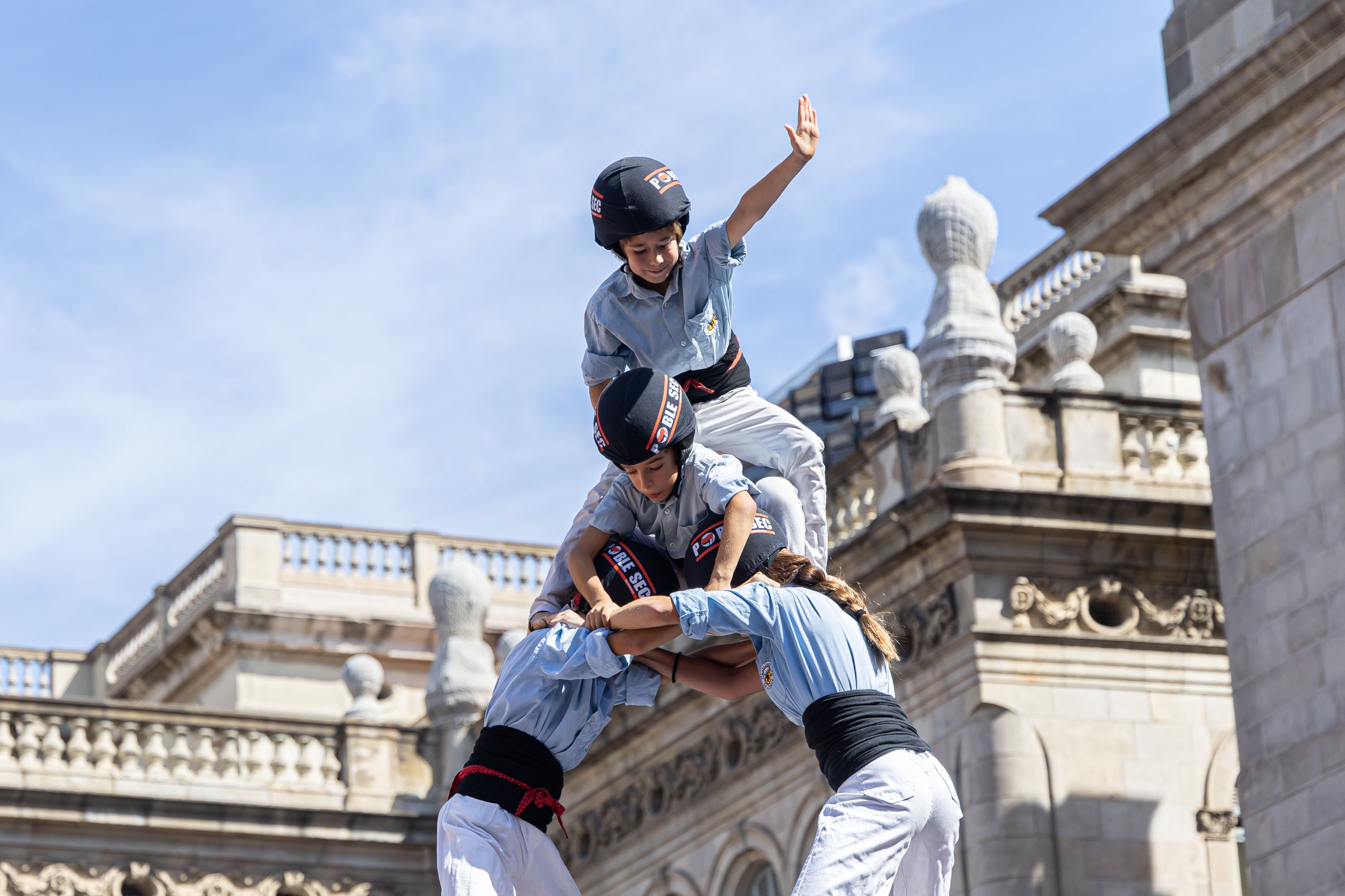 El anxaneta de los Castellers de Poble Sec corona el cielo durante la Diada Castellera. © Àngel Bravo