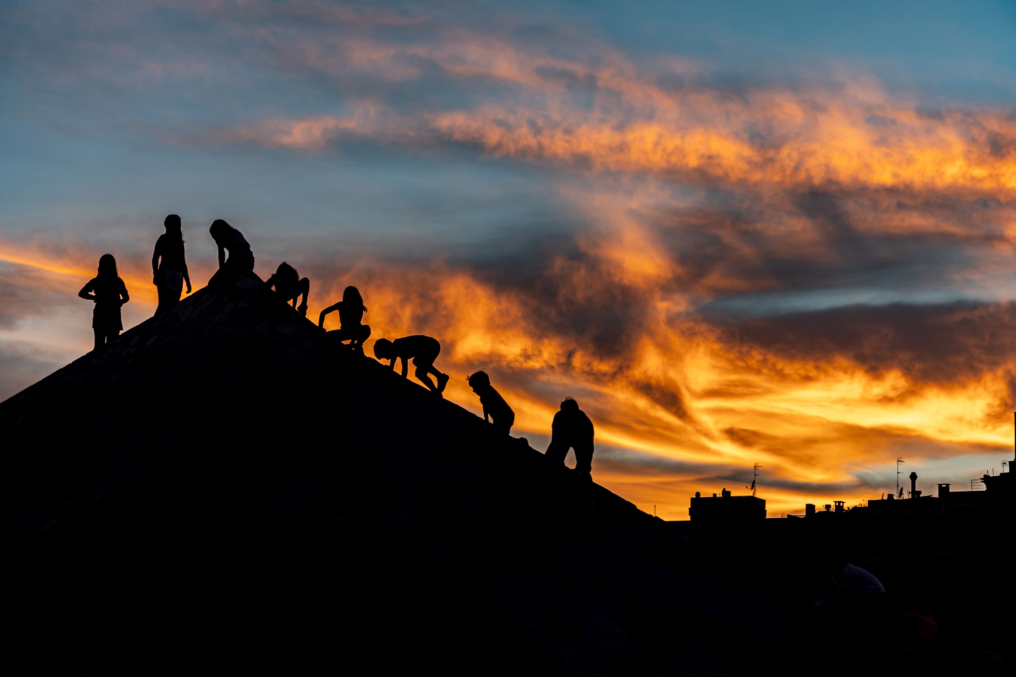 Niños juegan al atardecer, mientras el cielo se tiñe de tonos cálidos. © Àngel Bravo