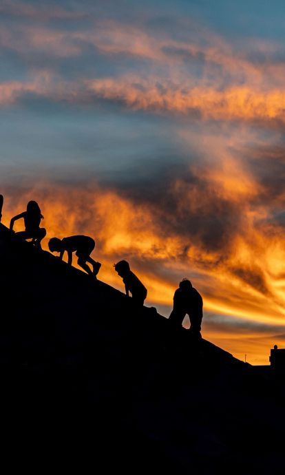 Children play at sunset as the sky fills with warm hues. © Àngel Bravo