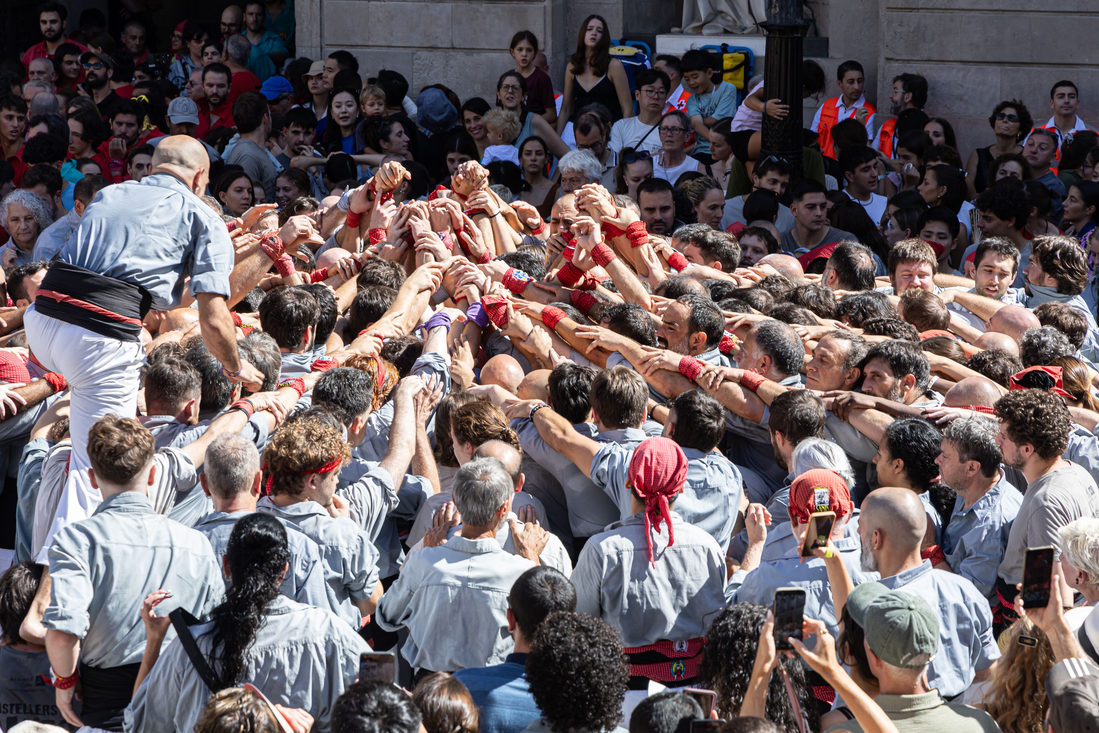 El momento en que la piña empieza a formarse para elevar el castell. © Àngel Bravo