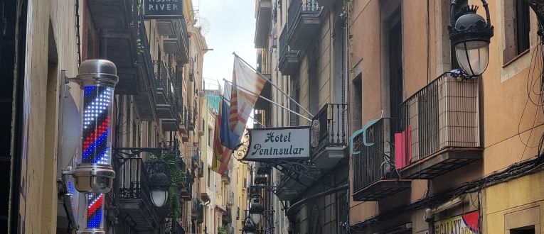 El cartel del Peninsular entre otros muchos de la Calle de Sant Pau, en el corazón del Raval de Barcelona (Javier Ortega Figueiral) El cartel del Peninsular entre otros muchos de la Calle de Sant Pau, en el corazón del Raval de Barcelona (Javier Ortega Figueiral)
