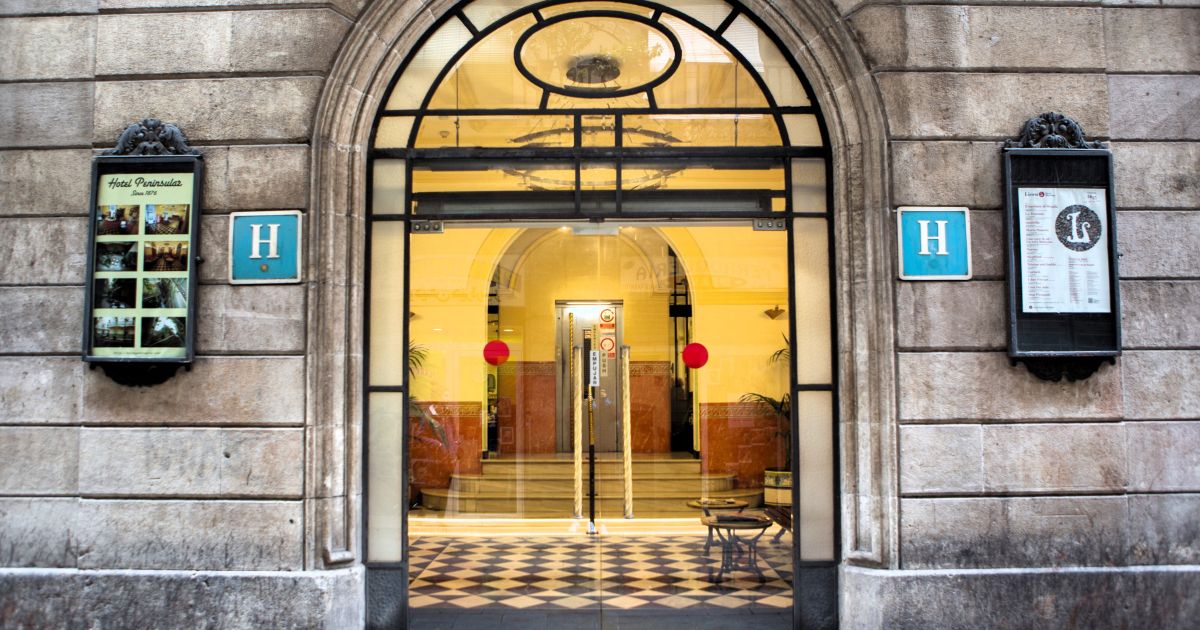 Acceso al hotel. En el cartel de la derecha siempre anunciada la temporada del Liceu. El teatro de la ópera es vecino del Peninsular (Turisme de Barcelona) Acceso al hotel. En el cartel de la derecha siempre anunciada la temporada del Liceu. El teatro de la ópera es vecino del Peninsular (Turisme de Barcelona)