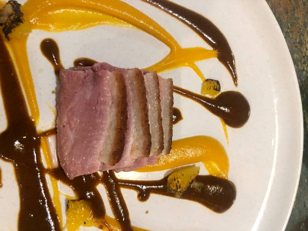 Magret de pato “Aylesbury” de bellota con mole, puré de boniato y naranja a la llama.