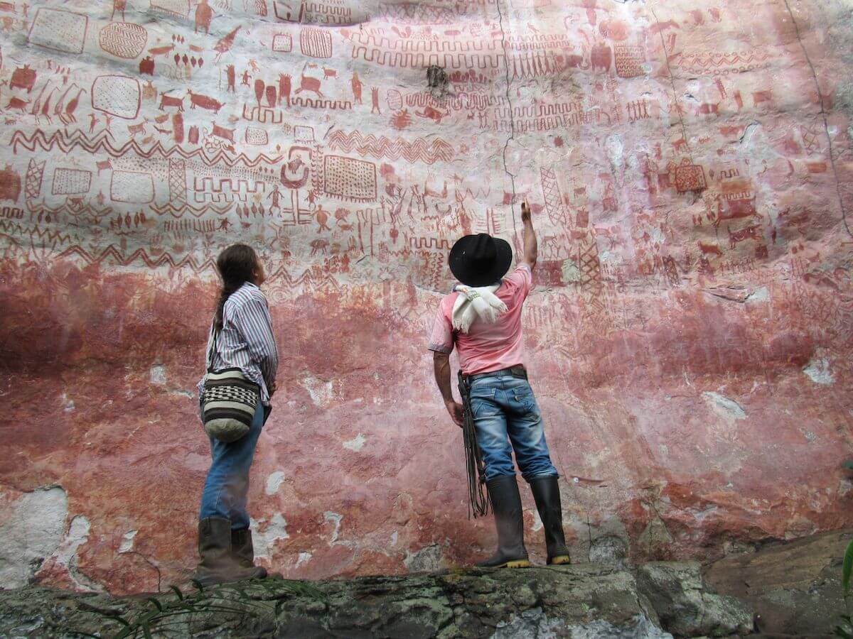 Personas ante las pinturas de la serranía de Lindosa.
