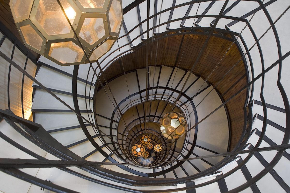 La famosa escalera de caracol del Cotton House, diseñada por Rubió i Tudurí, una estructura heredada de la segunda vida de la casa.
